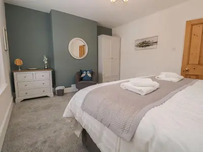 a bedroom with a bed with two towels on it at Derwent Cottage in Keswick