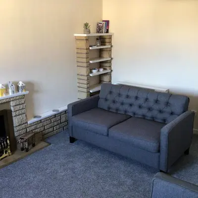 a blue couch in a room with a fireplace at Bobs plac in Whitehaven