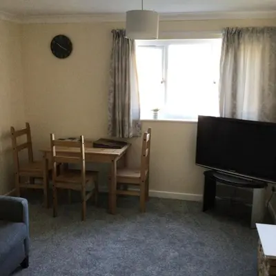 a living room with a table and chairs and a television at Bobs plac in Whitehaven