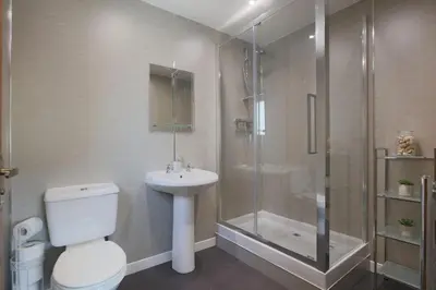 a bathroom with a shower and a toilet and a sink at Croftdean in East Barcloy