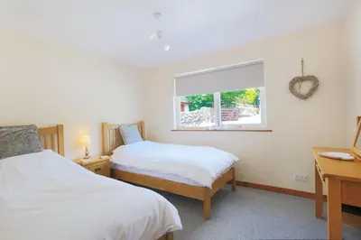 a bedroom with two beds and a window at Croftdean in East Barcloy