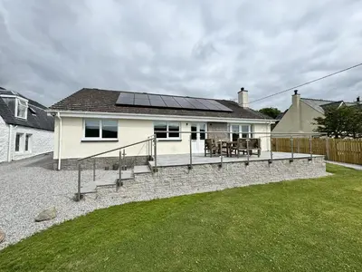 a house with a deck with solar panels on it at Croftdean in East Barcloy