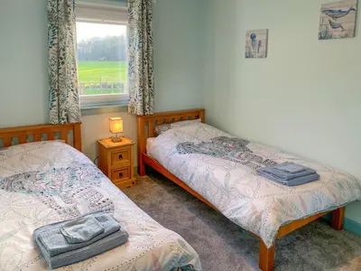 two twin beds in a room with a window at Ardwell Park in Ardwell