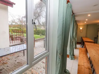 a door to a balcony with a view of a table at Old School Muncaster House in Ravenglass