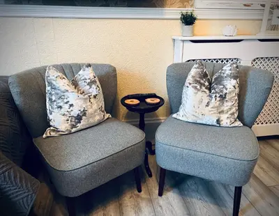 two chairs in a living room with pillows on them at Ashleigh House in Carlisle
