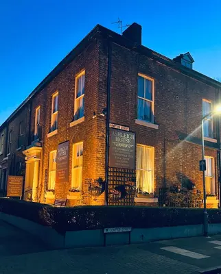 a brick building with a sign on the side of it at Ashleigh House in Carlisle
