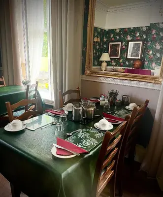 a dining room table with a green table cloth at Ashleigh House in Carlisle