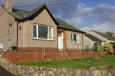 a house with a brick wall and a fence at Springfield in Dalbeattie