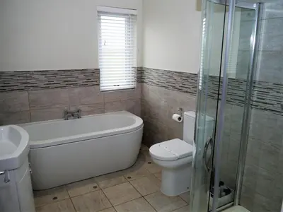 a bathroom with a tub and a toilet and a sink at Firpoint in Rockcliffe