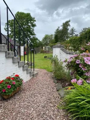 a garden with flowers and a stone staircase at St John's Flat Spacious Accomodation in Dalry
