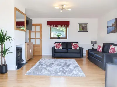 a living room with a couch and a fireplace at The Byre - Camp Douglas - Cottage in Crossmichael