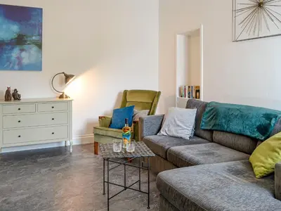 a living room with two couches and a table at Park Crescent - Cottage in Creetown