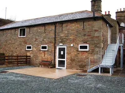 a brick building with a staircase next to a door at The Bird Bath - Cottage in Wreay