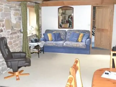 a living room with a blue couch and a chair at The Bird Bath - Cottage in Wreay