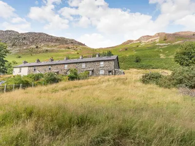 an old house on a hill in a field at High Rakes in Glenridding