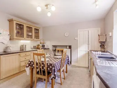a kitchen with a table and chairs and a kitchen with a sink at High Rakes in Glenridding