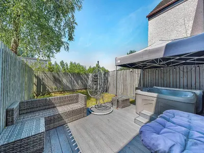 a patio with a bed and a fan on a fence at 3 Ladyknowe Uk39969 in Moffat