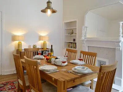 a dining room with a wooden table and chairs at Cardoness Houses in Dumfries