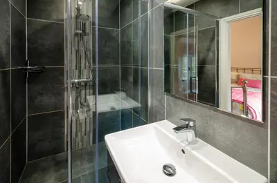 a bathroom with a sink and a shower and a mirror at Bank View in Chapel Stile