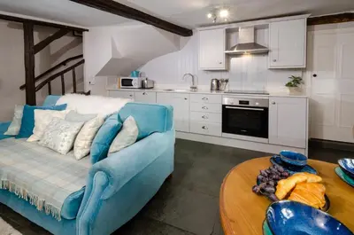 a living room with a blue couch and a table at Bank View in Chapel Stile
