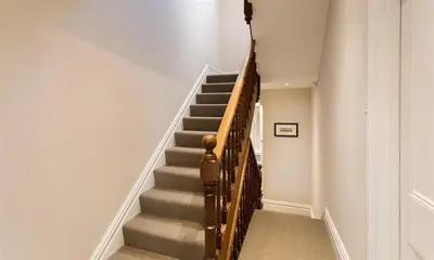 a staircase in a home with a wooden rail at Thirty Blencathra Street in Keswick