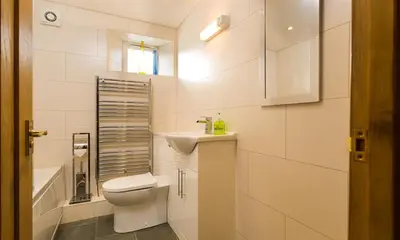 a white bathroom with a toilet and a sink at Agathi in Keswick