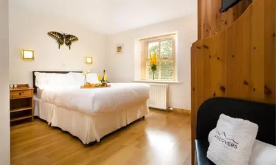 a bedroom with a large white bed and a window at Agathi in Keswick
