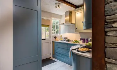 a kitchen with blue cabinets and a plate of food at Acorn Cottage in Grasmere