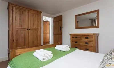 a bedroom with a bed with two towels on it at Pollys Cottage in Elterwater