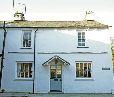 a white house with a door on a street at Pollys Cottage in Elterwater