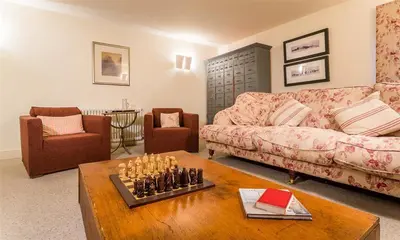 a living room with a couch and a chess board at Thimble Hall in Grasmere