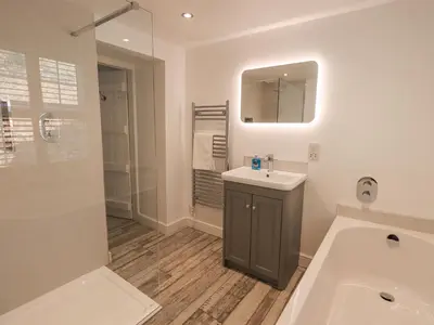 a bathroom with a sink and a tub and a mirror at Slaters Rest in Chapel Stile