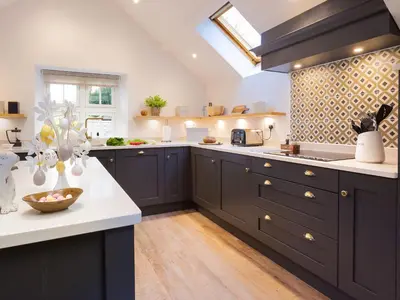 a kitchen with dark blue cabinets and white counter tops at Tilly's Cottage in Grasmere