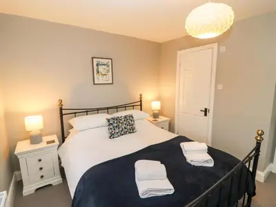 a bedroom with a bed with two towels on it at Tilly's Cottage in Grasmere
