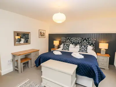 a bedroom with a bed with a blue comforter at Tilly's Cottage in Grasmere