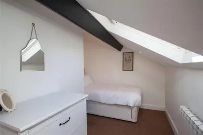 a white bedroom with a bed and a skylight at Robins Nest in Coniston