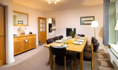 a dining room with a wooden table and chairs at Bowderstone in Keswick