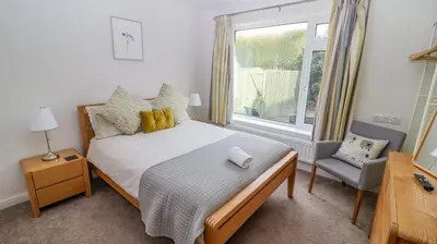 a bedroom with a bed and a window and a chair at Bowderstone in Keswick