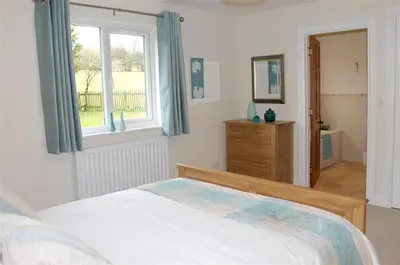 a bedroom with a bed and a window and a dresser at Bandol in Braithwaite