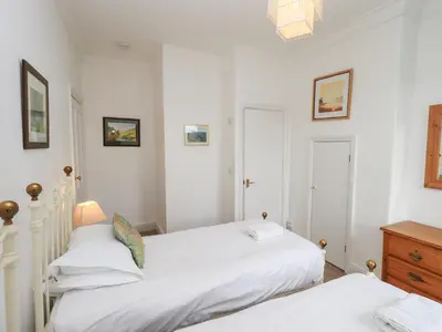 two beds in a bedroom with white walls at Number Twenty in Keswick
