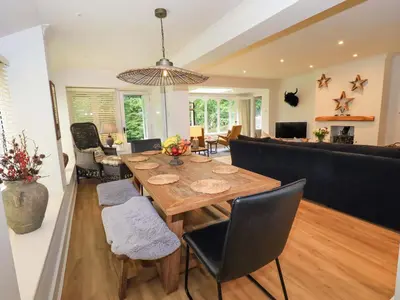 a dining room and living room with a table and chairs at Underheron in Grasmere