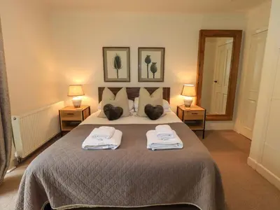 a bedroom with a large bed with towels on it at Underheron in Grasmere