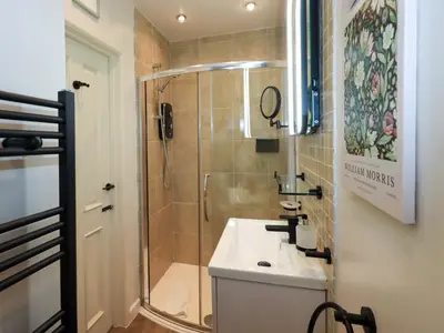 a small bathroom with a shower and a sink at Underheron in Grasmere