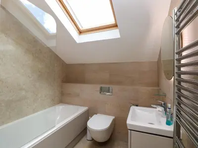 a bathroom with a toilet and a sink and a skylight at Rowanberry Cottage in Grasmere