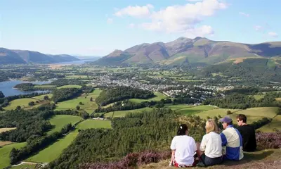 a group of people sitting on top of a hill overlooking a valley at Greengarth in Keswick