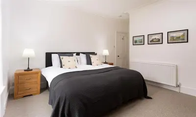 a bedroom with a large bed with a black blanket at Ben House in Grasmere