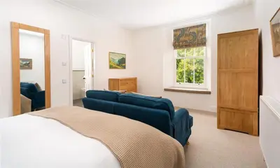 a bedroom with a blue couch and a bed at Ben House in Grasmere