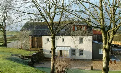 a large white house in the middle of a yard at Scalegill House in Cockermouth