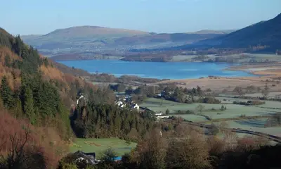 a view of a valley with a lake and mountains at Scalegill House in Cockermouth