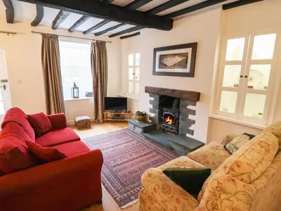 a living room with a couch and a fireplace at Weir Cottage in Ambleside